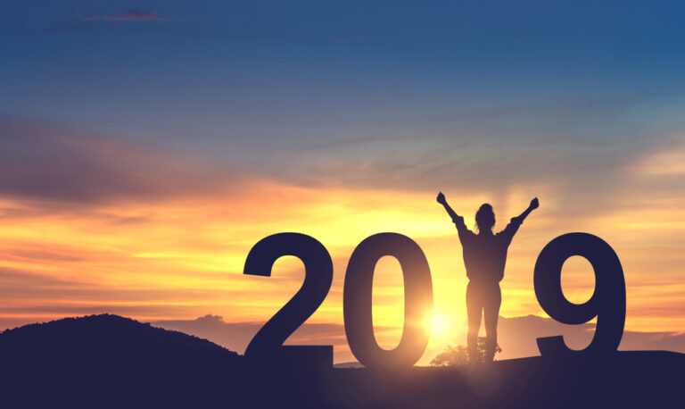Big block numbers, with a woman as the number one in 2019 in front of a sunset.