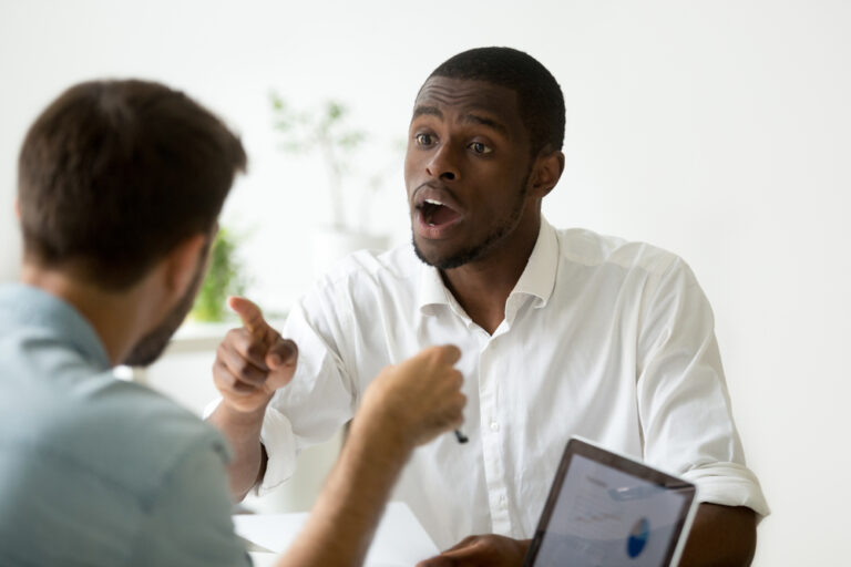 African American man pointing at a white man in a heated discussion.