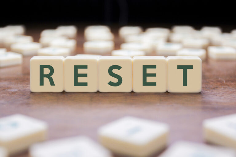 Close up of the word RESET written with scrabble tiles.
