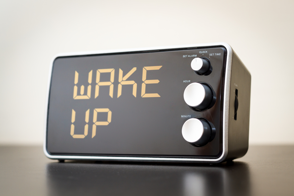 Alarm clock on table with the words 'Wake Up' on the alarm time slot